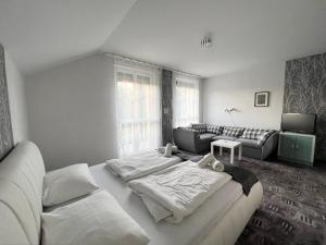 a living room with a bed and a couch at Wolf Panzió in Sárvár