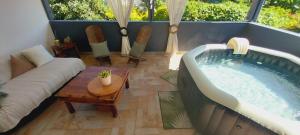 ein Wohnzimmer mit einem Whirlpool und einem Sofa in der Unterkunft villa le volubilis in Le Tampon