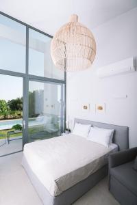 um quarto com uma cama grande e um lustre em Sevene Villas em Petroúlai