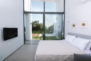 a bedroom with a bed and a television and a patio at Sevene Villas in Petroúlai