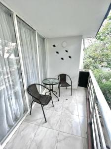a balcony with two chairs and a table and a television at APARTAMENTO 401 MEDELLIN in Medellín