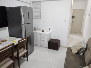 a kitchen with a dining table and a refrigerator at Ap no centro de Florianopolis in Florianópolis