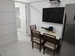 a kitchen with a table with two chairs and a refrigerator at Ap no centro de Florianopolis in Florianópolis