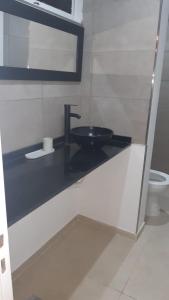 ein Bad mit einem schwarzen Waschbecken und einem WC in der Unterkunft 9y45 in La Plata
