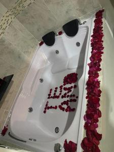uma banheira branca cheia de rosas vermelhas em HOTEL LUXEM em Bogotá