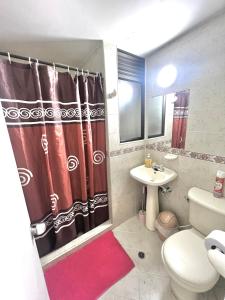 a bathroom with a red shower curtain and a sink at APARTAMENTO 401 MEDELLIN in Medellín