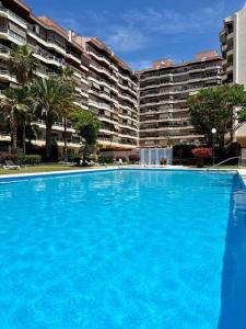 una gran piscina azul frente a un gran edificio en Vista al mar - Piscina by VV Canary Ocean Homes, en Los Cristianos