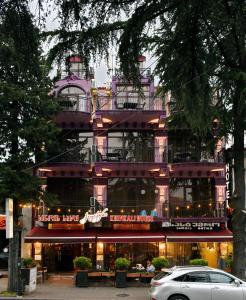 ein lila Gebäude mit einem Restaurant davor in der Unterkunft Antika Hotel in Batumi