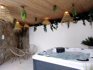a hot tub in the middle of a patio with chairs at Lodges Minho in Ponte da Barca