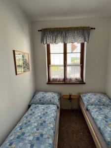 2 camas en una habitación con ventana en Apartmán u Čarků 