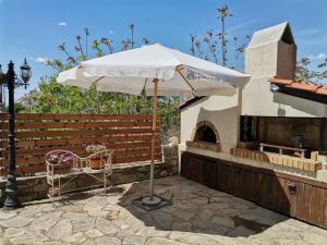 a white umbrella sitting next to a brick oven at Maronia Luxury Villa in Maronia