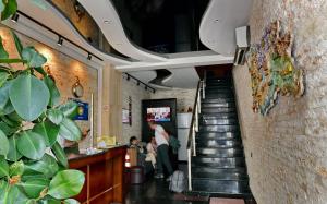 eine Treppe in einem Restaurant mit Leuten auf der Theke in der Unterkunft Antika Hotel in Batumi