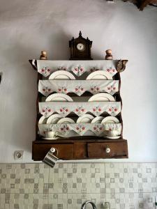 ein Regal mit Platten und eine Uhr an der Wand in der Unterkunft La Casa Cottage in Chania