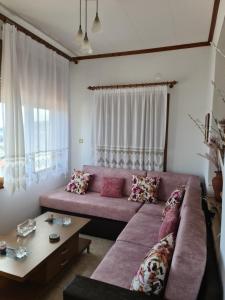 a living room with a pink couch and a table at Votsi Seaview in Alonnisos Old Town