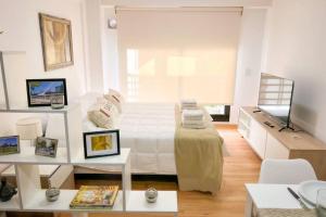 Habitación blanca con cama y TV en Jufre I - Amazing Studio in Palermo Soho en Buenos Aires