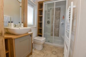 a bathroom with a sink and a toilet and a shower at Lakewood retreat in Woodhall Spa