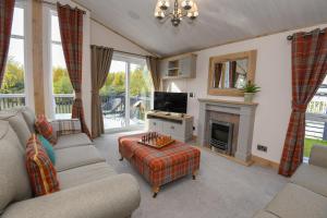 a living room with a couch and a tv at Lakewood retreat in Woodhall Spa
