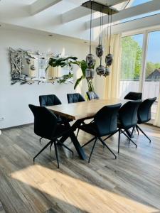 uma sala de jantar com uma mesa de madeira e cadeiras em Apartment 160qm 5 Schlafzimmer 1 Wohnzimmer Terrasse und Balkon em Wilhelmshaven