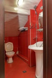 a red bathroom with a toilet and a sink at Antika Hotel in Batumi