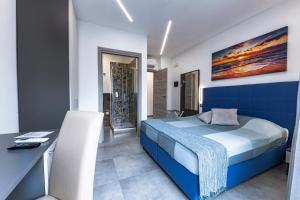1 dormitorio con cama azul y escritorio en BNB Aria di Mare en Santa Marinella