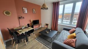 a living room with a couch and a table and a dining room at appartement cosy in Boulogne-sur-Mer