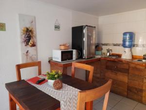 a kitchen with a wooden table and a microwave at Cabañas Refugio Nativo in Santa Cruz