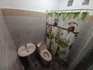 a bathroom with a monkey shower curtain and a toilet at Hostal Santa Marta in La Unión