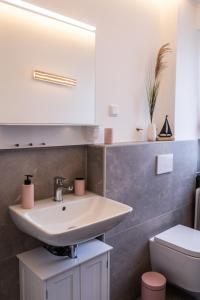 a bathroom with a sink and a toilet at Golden Hour Apartment Wangerooge in Wangerooge