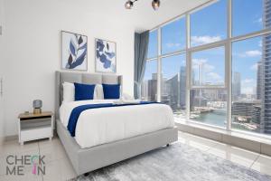 een slaapkamer met een groot bed en een groot raam bij Luxury 2BR with Breath-taking Dubai Marina Views in Dubai