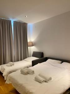 2 camas en una habitación de hotel con sábanas blancas en Apartman 20, Brzeće Centar en Brzeće