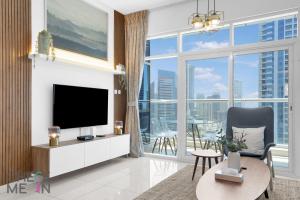 een woonkamer met een tv en een groot raam bij Luxury 2BR with Breath-taking Dubai Marina Views in Dubai