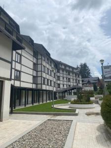 a large building with a courtyard in front of it at Apartman 20, Brzeće Centar in Brzeće