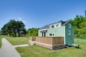 een groen tiny house op een onverharde weg bij Green Tiny House with shared pool in Zeewolde