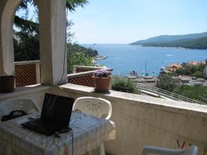 a laptop computer sitting on a table on a balcony at Apartments Lory in Rabac