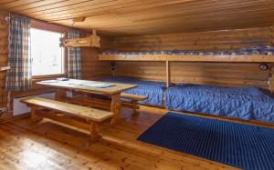 a room with a bed and a table in a cabin at Tunturikeskus Galdotieva in Leppäjärvi