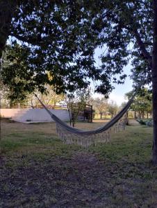 a hammock hanging from a tree in a park at El RANCHO in San Martín