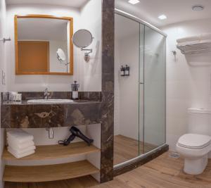 a bathroom with a shower and a sink and a toilet at Wyndham Gramado Termas Resort & Spa in Gramado