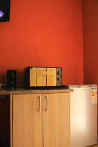 a microwave sitting on top of a counter next to a refrigerator at 7th Dimension Guesthouse in Zeerust