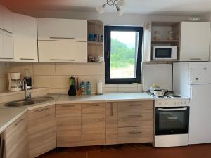 eine Küche mit weißen Geräten und einem Fenster in der Unterkunft Zelena dolina-Green Valley in Travnik