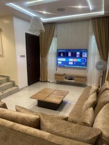 sala de estar con sofá y TV en Urban Haven - Surulere, en Lagos