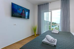 a bedroom with a bed with towels and a large window at Apartment Vidra in Brela