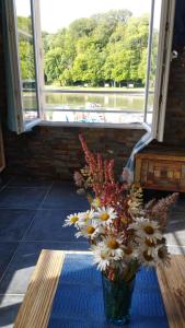 un vaso di fiori su un tavolo di fronte a una finestra di studio vue sur le Port saint Goustan classé 3 étoiles! ad Auray
