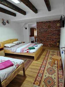 two beds in a room with a brick wall at Casa de Vacanta Neagu in Gura Teghii +32 photos