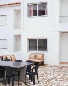 a patio with a table and chairs and a building at Baleal Surf Emotions in Baleal