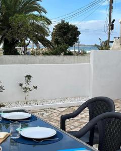 a table with two chairs and a table with plates on it at Baleal Surf Emotions in Baleal