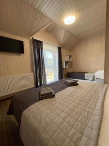 布克維的住宿－Приватна садиба Соломія，一间卧室设有一张大床和一个窗户。
