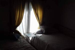 a bedroom with a window with a laptop on a bed at club de campo los horneros in Ingeniero Maschwitz
