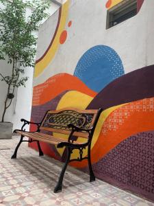 a bench in front of a wall with a mural at MiBAQ Palermo in Buenos Aires