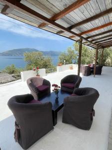 a table and chairs on a patio with a view of the water at Marios Rooms in Vlorë