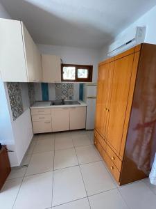 a small kitchen with white cabinets and a window at Marios Rooms in Vlorë